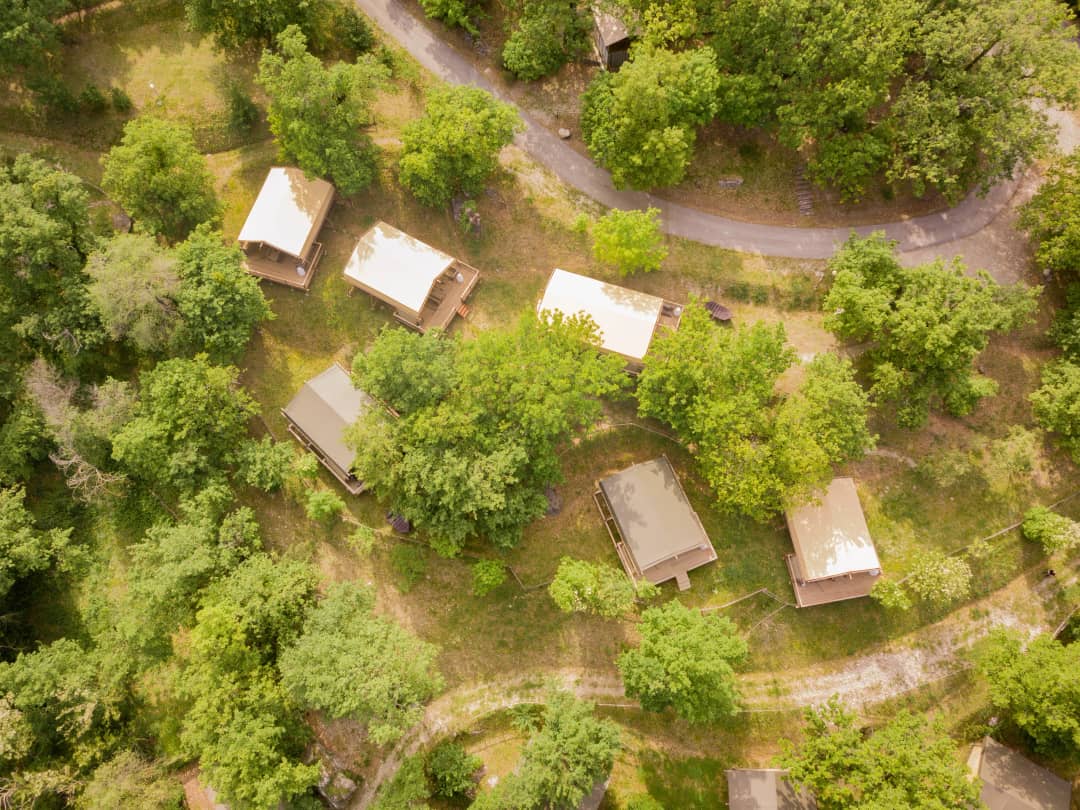 Vue aérienne des Desert Lodges disséminés parmi les arbres, le long d'un sentier sinueux