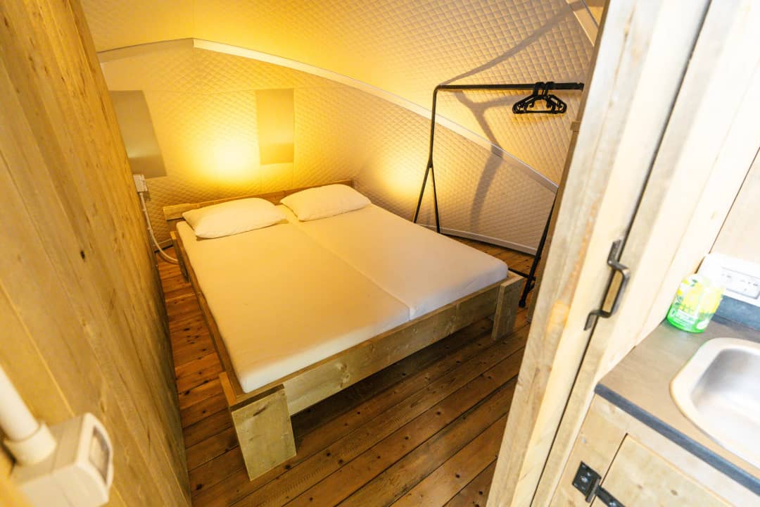 Chambre avec un lit double et des murs en bois