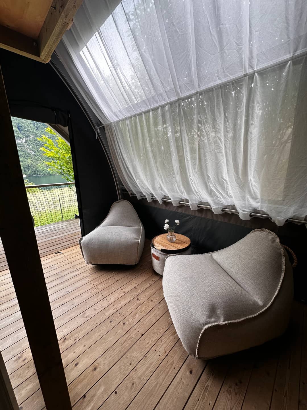 Coin salon avec des poufs sous le rideau clair dans le Big Oak Lodge XS