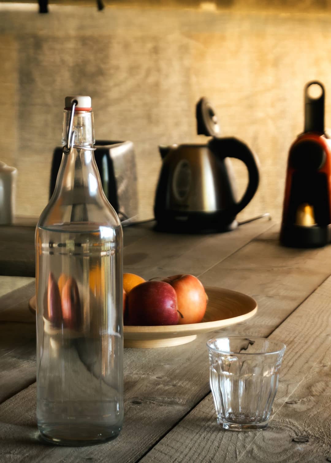 Table avec une carafe d'eau, des fruits et une bouilloire