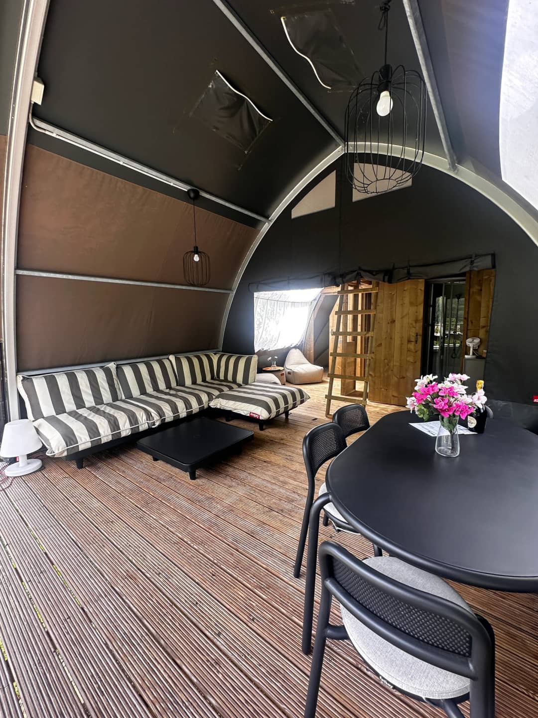 Coin salon avec des coussins rayés et une table à manger décorée de fleurs