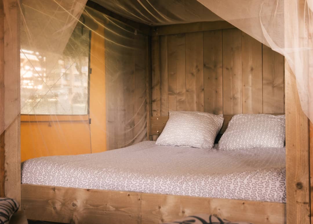 Lit double au Base Lodge avec une paroi en bois