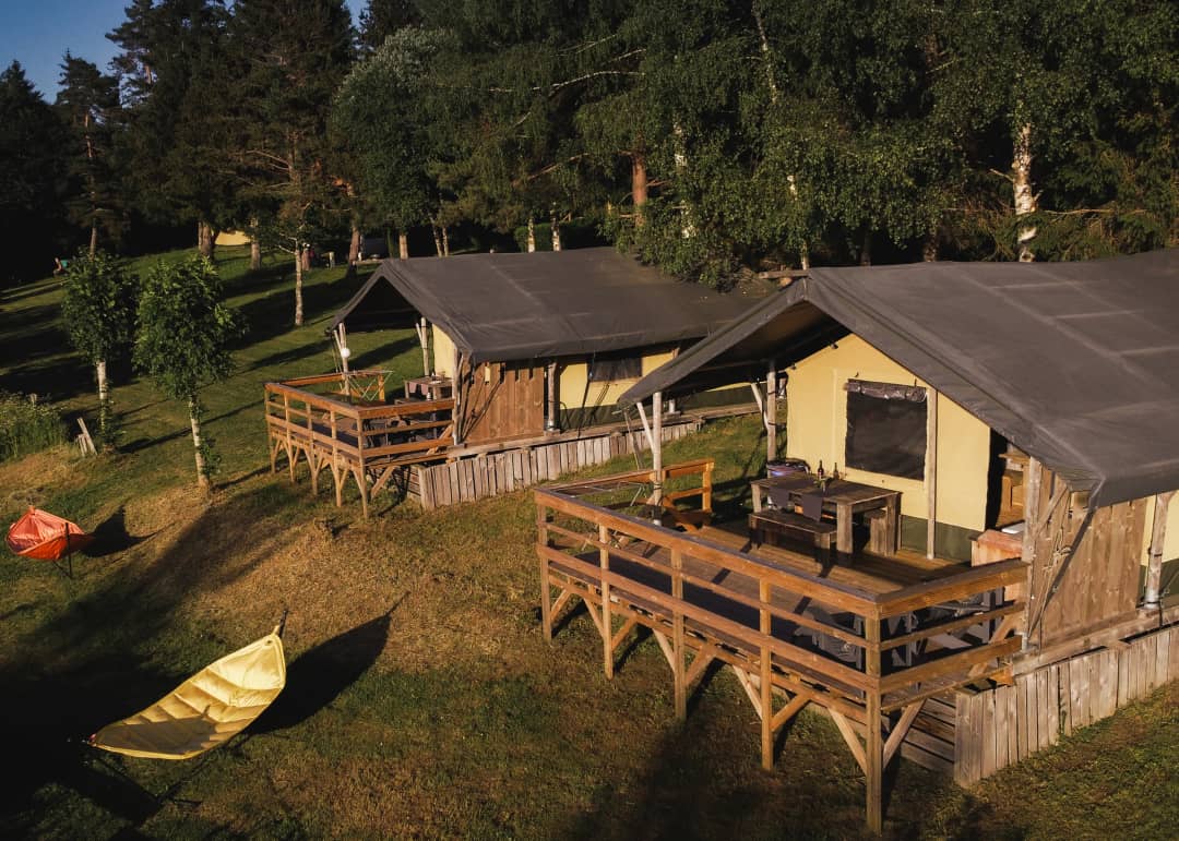 Deux chalets « Base Lodges » sur pilotis avec terrasse, baignés par le soleil du soir, aux Sapins